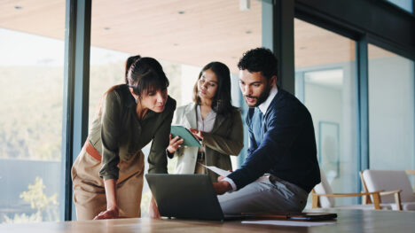 Collaboration, laptop and project management with business people in office for plan development. Computer, meeting and tablet with corporate employee team in workplace boardroom for discussion